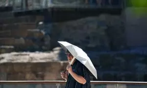 Varias personas intentan protegerse de las altas temperaturas que azotan estos días la capital malagueña, a 3 de agosto de 2023 en Málaga, (Andalucía).