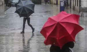 Dos personas sostienen paraguas como consecuencia de la lluvia, a 6 de febrero de 2023, en Valencia, Comunidad Valenciana (España).