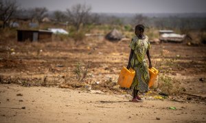 Una mujer camina por la carretera con bidones de agua, a 26 de enero de 2024 en Sudán del Sur, Juba.
