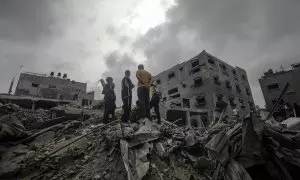 Algunas personas buscan cadáveres y supervivientes entre los escombros de una casa destruida tras un ataque aéreo israelí en el campo de refugiados de Al Nusairat, sur de la Franja de Gaza, el 27 de abril de 2024.