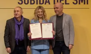 Yolanda Díaz (c), junto a los secretarios generales de CCOO, Unai Sordo (d), y de UGT, Pepe Álvarez (i), durante la firma del acuerdo para la subida del 5% del SMI, a 17 de enero de 2024.