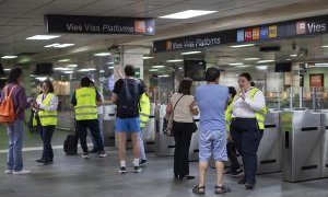 Una informadora da indicaciones a varios usuarios en la estación de cercanías de Renfe de Plaça Catalunya (Barcelona), el 12 de mayo de 2024.