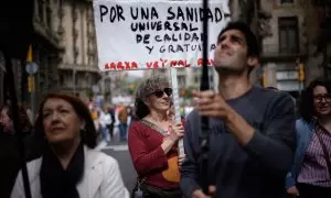 Una mujer sujeta un cartel de protesta durante una manifestación contra la privatización de la sanidad, a 7 de abril de 2024, en Barcelona, Catalunya (España).