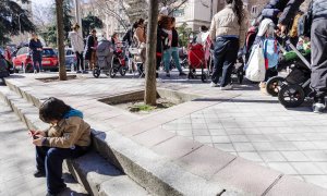 Un grupo de persona espera una cola durante la entrega de ropa de abrigo y zapatos nuevos a niños vulnerables, a 24 de febrero de 2023, en Madrid (España).