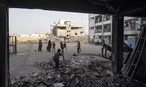 Un grupo de palestinos desplazados se aloja en una escuela de la UNRWA destruida después de que el Ejército israelí les pidiera evacuar la ciudad de Rafah.