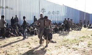 Un grupo de migrantes junto a la valla fronteriza de Melilla.