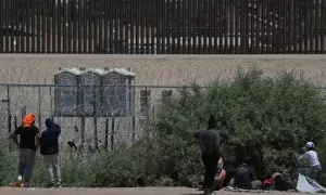 Policías de la Guardia Nacional de Texas dialogan por medio de altavoces con migrantes, en el muro que divide a México con Estados Unidos.
