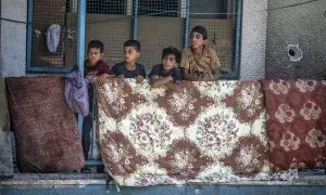 Niños palestinos desplazados en un balcón de la escuela de la UNRWA destruida por los bombardeos de Israel.