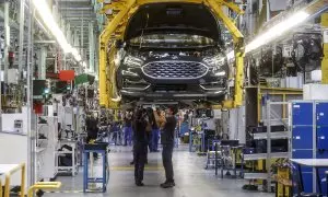 Dos trabajadores con un vehículo de la fábrica de Ford en Almussafes, a 24 de octubre de 2022.