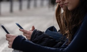 Foto de archivo de dos menores utilizando el teléfono móvil, a 1 de febrero de 2024, en Barcelona, Catalunya.