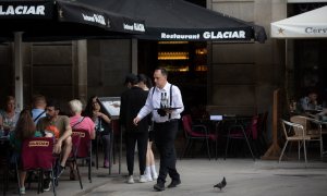 Foto de archivo de un camarero sosteniendo una bandeja en la plaza Real de Barcelona, a 15 de junio de 2022, en Barcelona, Catalunya.