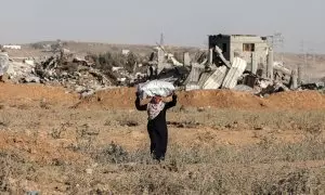 Una muejr palestina carga un saco con sus pertenencias después de los ataques israelíes, en Khan Younis, a 2 de julio de 2024.