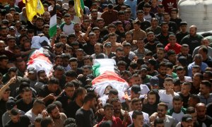 Varias personas cargan con los cuerpos de dos palestinos asesinados por fuerzas israelíes en un funeral en Cisjordania, a 3 de noviembre de 2023.