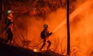 Dos bomberos apagan un incendio en Castrelo de Miño (Ourense), en julio de 2022.