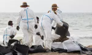 Varios operarios trabajan en la limpieza de la playa afectada por el vertido de hidrocarburos en València, a 17 de julio de 2024.