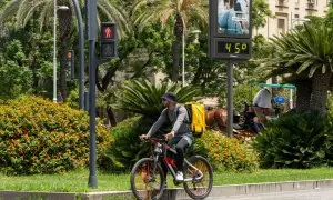 Un termómetro marca 45 grados a las 14:00 de la tarde junto a un trabajador de Glovo en bicicleta, a 19 de julio de 2024, en Sevilla, Andalucía (España).