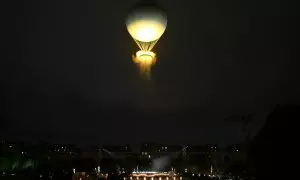 Un globo que porta el pebetero con la llama olímpica vuela durante la ceremonia inaugural de los Juegos Olímpicos de París 2024.