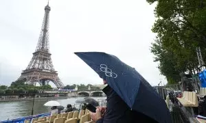 26 de julio de 2024. Un turista bajo un paraguas en la ceremonia de inauguración de los Juegos Olímpicos.