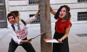 Dos personas con caretas de Almeida y Ayuso fingen talar un árbol durante una manifestación contra la tala de árboles por la ampliación de la L11 de Metro, en la Puerta del Sol, a 8 de octubre de 2023, en Madrid (España).