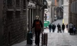 09/08/2024 Una persona camina con dos maletas en Barcelona, Catalunya. Foto de arhivo.