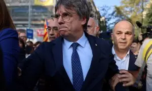 El expresident Carles Puigdemont, rodeado de dirigentes de Junts, abandona el escenario tras una breve intervención en su reaparición en Barcelona tras siete años de exilio. REUTERS/Nacho Doce