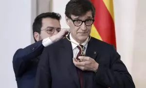 El president sortint, Pere Aragonès, entrega la medalla al president electe, Salvador Illa, en l'acte de presa de possessió del càrrec de president de la Generalitat.