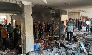 Palestinos inspeccionan los daños tras un ataque israelí que mató al menos a 100 personas en una escuela que albergaba desplazados en la ciudad de Gaza.