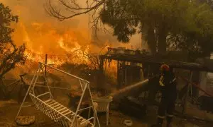 Un bombero combate el fuego en una vivienda al norte de Atenas