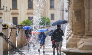 Foto de archivo de transeúntes  con paraguas durante las fuertes lluvias, en Sevilla.