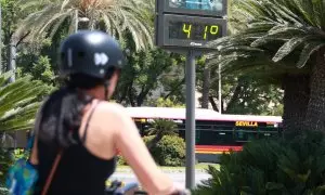 Una joven se resguarda del sol con un abanico para soportar las altas temperaturas, en Sevilla.