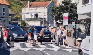 Vecinos de O Hío (Pontevedra) cortan el tráfico cruzando la calle de forma ininterrumpida.