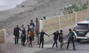 Agentes de la Guardia Civil junto a un grupo de migrantes que llegó a nado a Ceuta este lunes.