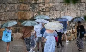 28/08/2024 Transeúntes protegidos con paraguas durante las fuertes lluvias en Sevilla. Foto de archivo.