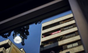 Un cartel de 'Se Vende' de una inmobiliaria se refleja en el cristal de un escaparate, en Ourense. E.P./Agostime / Europa Press