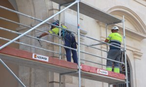 Foto de archivo de dos operarios trabajando en el montaje de andamios