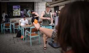 Una dona dispara una pistola d'aigua contra uns turistes en un restaurant de menjar ràpid