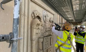 Unos operarios eliminan del edificio del antiguo Palacio de Justicia de Vitoria el último escudo de la época franquista que quedaba visible en las calles de la ciudad.