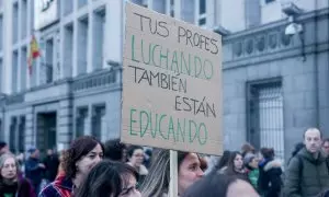 Dos personas sostienen un cartel durante una manifestación por una educación pública y de calidad, a 27 de febrero de 2024.