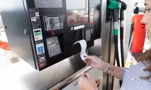 Cliente recoge un recibo en la gasolinera.