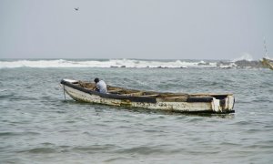 Niño sentado en una 'pirogue', mejor conocido como cayuco, en la playa de Yoff Thongor, Dakar