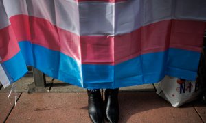 Los zapatos de una mujer debajo de una bandera trans durante una concentración de la Federación Plataforma Trans, a 28 de octubre de 2022, en Madrid.