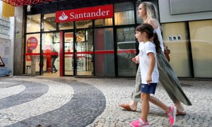 Una mujer y un niño pasan por delante de una oficina del Banco Santander en Rio de Janeiro (Brasil). REUTERS/Sergio Moraes