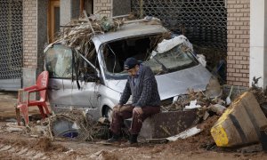 Un vecino descansa en una de las calles afectadas en Paiporta.