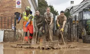 Miembros del Ejército de Tierra y bomberos Forestales limpian las calles tras el paso de la DANA en Utiel (València).