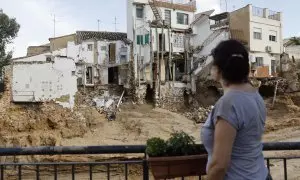 Una mujer frente a varias casas dañadas en Chiva, València, tras la DANA.