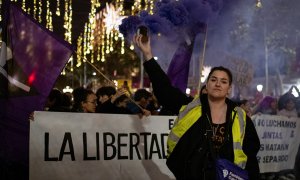 Una mujer con un bote de humo morado, durante una manifestación por el 25N en Barcelona.