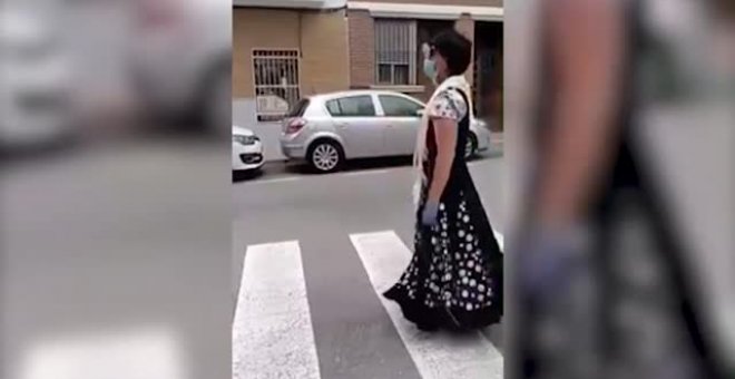 Se salta el confinamiento disfrazado con un vestido de sevillana y cantando en plena calle para celebrar la feria de abril en Alicante