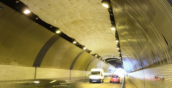 Dos jóvenes lanzan botellas a la calzada en el túnel de Tetuán