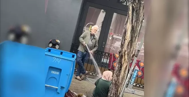 Racismo y aporofobia en estado puro: un hombre lanza agua con una manguera a una mujer negra sin hogar