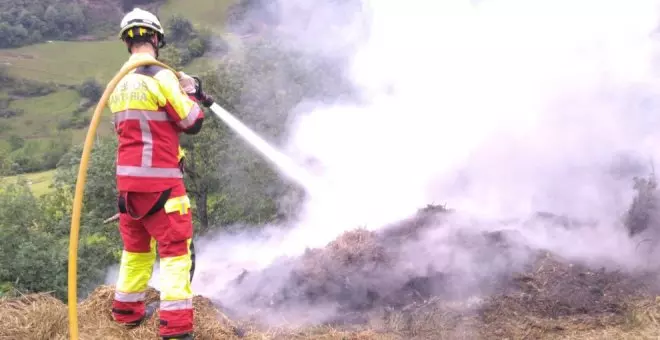 Los bomberos sofocan un incendio en una zona de hierba seca en Bárago